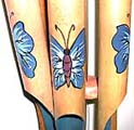 Bamboo windchime with blue color butterflies on each pipe and blue painted inside each pipe, flat half nut shell on top