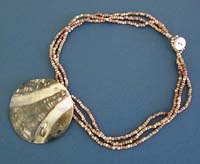 Fashion necklace in triple brown beaded string design with a white line band pattern seashell pendant decor, button loop for convenience closure