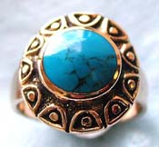  bronze ring with flower pattern holding a rounded genuine blue turquoise stone at center 