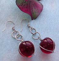 Fashion earring with wired-in transparent red glass bead suspended and mini double loop design