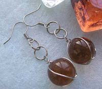 Double loop fashion earring with wired-in brown glass bead suspended